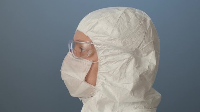 Portrait of masked laborant on gray back.