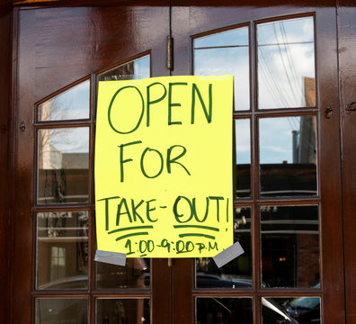 Open For Take Out Poster Taped On Windows Of Restaurant