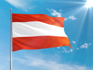 Fototapeta na wymiar Austria national flag waving in the wind against deep blue sky. High quality fabric. International relations concept.