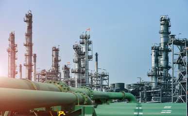 Pipe line front of Oil and gas industrial, Oil refinery plant from industry, Refinery Oil storage tank and pipe line steel with blue sky and white clouds background.