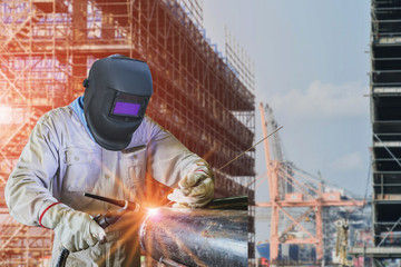 welder is welding construction site wearing equipment protection PPE for safety concept on...