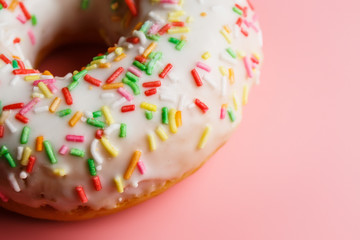 
Two juicy fresh sweet donuts with sugar icing and sprinkles on a pink background