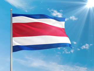 Costa Rica national flag waving in the wind against deep blue sky. High quality fabric. International relations concept.