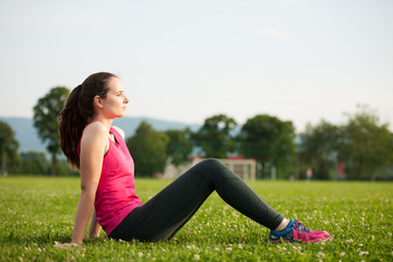 Fototapeta na wymiar Beautiful young woman rests after a long run workout outdoor in nature
