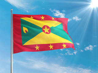 Grenada national flag waving in the wind against deep blue sky. High quality fabric. International relations concept.