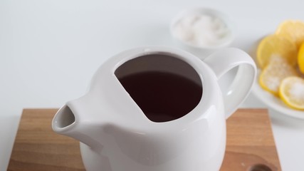Poured boiling water in white teapot on table. Close up.