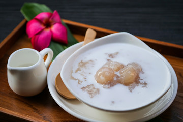 Sticky rice boiled in syrup with longan and coconut milk dressing. Thai dessert