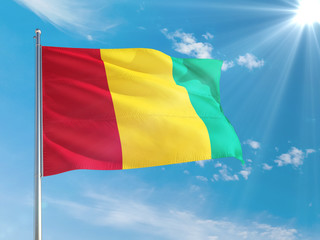Guinea national flag waving in the wind against deep blue sky. High quality fabric. International relations concept.