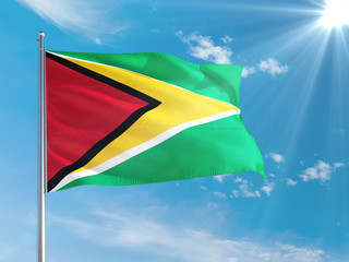 Guyana national flag waving in the wind against deep blue sky. High quality fabric. International relations concept.