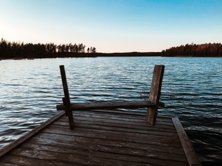 Bench on the pier in front of the lake in Sweden.