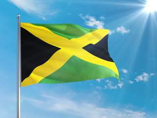 Jamaica national flag waving in the wind against deep blue sky. High quality fabric. International relations concept.