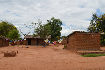 African homes with colorful clothes for drying along the road in Lolongwe, Malawi - one of the...