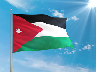Jordan national flag waving in the wind against deep blue sky. High quality fabric. International relations concept.