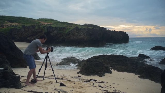 A Photographer In Shorts Capturing The Beauty Of Indian Ocean In Watamu Beach In Mombasa, Kenya. -wide shot