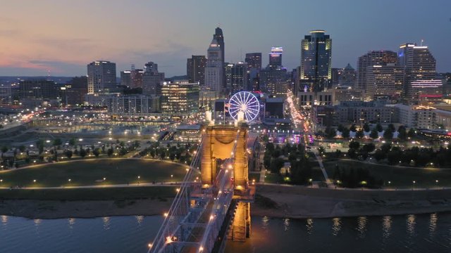 Aerial: Downtown Cincinnati, John A. Roebling Suspension Bridge on the Ohio River at sunset. Ohio, USA. 