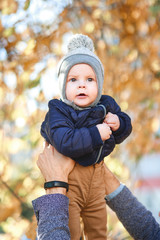 A laughing father holds a beautiful child in his arms against