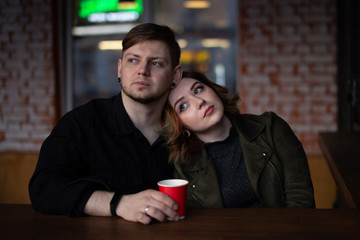 Young beautiful couple of boyfriend and girl lovers are sitting in a cafe.