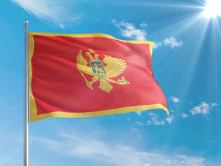Naklejka na ściany i meble Montenegro national flag waving in the wind against deep blue sky. High quality fabric. International relations concept.