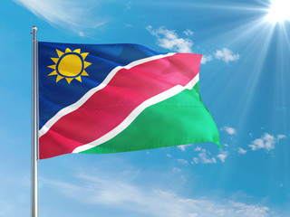 Namibia national flag waving in the wind against deep blue sky. High quality fabric. International relations concept.