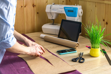 the girl sews clothes at home, works remotely, builds a pattern, seamstress