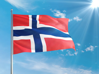 Norway national flag waving in the wind against deep blue sky. High quality fabric. International relations concept.