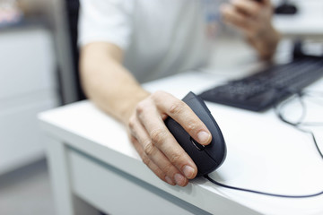 In the man’s hand, a vertical ergonomic computer mouse-joystick is used.