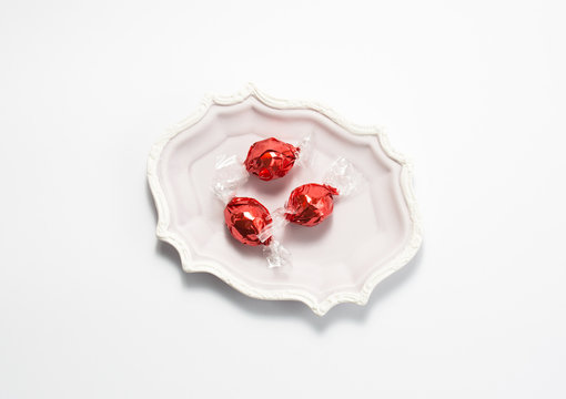 three red candies on a white background.