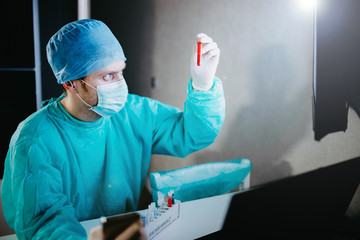 medical lab technician works with blood samples in a laboratory. The doctor is working in the...
