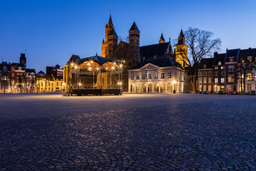Fototapeta na wymiar Unique view of a empty Vrijthof square and no people in downtown Maastricht during blue hour with the ancient churches and former military house