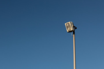 Large industrial exterior light isolated against a blue sky, copy space, horizontal aspect