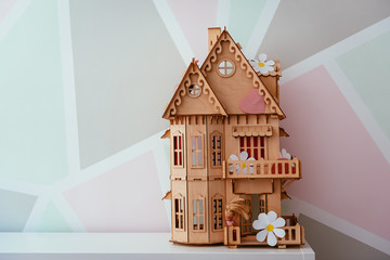 wooden toy house on a background of a beautiful wall