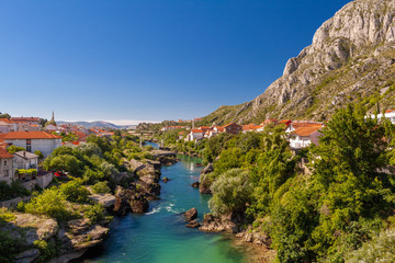 Fototapeta na wymiar view of the Neretva river, blue sky houses in Mostar, Bosnia and Herzegovina