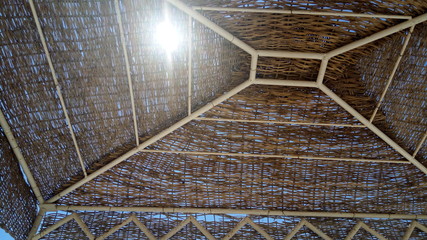   sunshine through straw umbrella, near cleopatra beach, holidays in Marsa Matrouh, Egypt