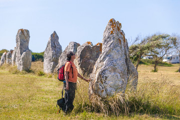 young woman in a field of megalithic menhirs in Brittany near Camaret sur Mer, France 