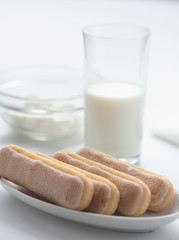 cookies milk in a glass and jug sour cream in a bowl