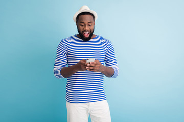 Photo of attractive dark skin guy traveler good mood hold telephone app browsing chatting friends...