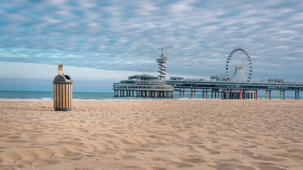 Beach of Scheveningen with a beautiful cloud cover and an empty trash can. Still life by carona virus