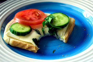Three diet sandwiches with cucumber, tomato and tofu cheese on a plate
