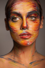 Portrait of a woman with a painted face. Creative makeup and bright style.