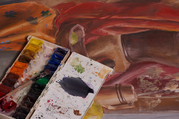 Master at work drawing made with gouache paints, still life. Paint cans and brushes hand of the...