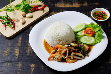 Rice topped with stir-fried pork, shrimp, squid and holy basil
