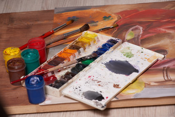 Master at work drawing made with gouache paints, still life. Paint cans and brushes hand of the...