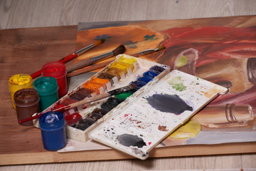 Master at work drawing made with gouache paints, still life. Paint cans and brushes hand of the master.