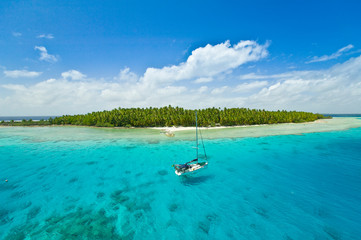 Sailing yachts anchoring in the shallow waters of suwarrow atoll, cook islands, polynesia, pacific...