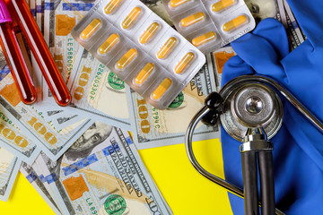 Money dollar with pills in blister on a stethoscope blood test tubes