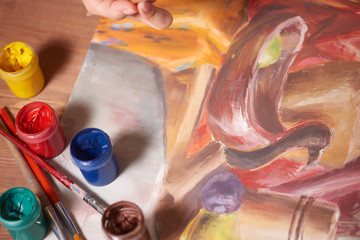Master at work drawing made with gouache paints, still life. Paint cans and brushes hand of the...