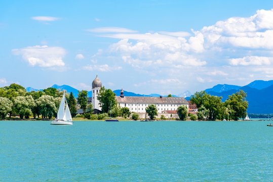 Chiemsee, Bavaria, Bayern, Germany. Beautiful view on lake with alps mountains, blue sky with clouds, monastery, church on island Frauenchiemsee