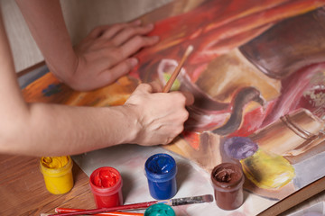 Master at work drawing made with gouache paints, still life. Paint cans and brushes hand of the master.