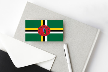 Dominica flag on minimalist letter background. National invitation envelope with white pen and...
