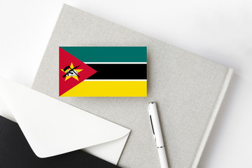Mozambique flag on minimalist letter background. National invitation envelope with white pen and...